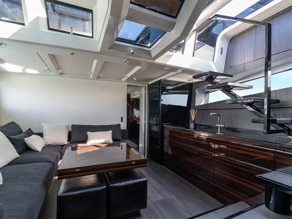 Midships equipped with a kitchen and a large corner sofa with a petal-shaped coffee table, which can be transformed into an eight-seater dining table.